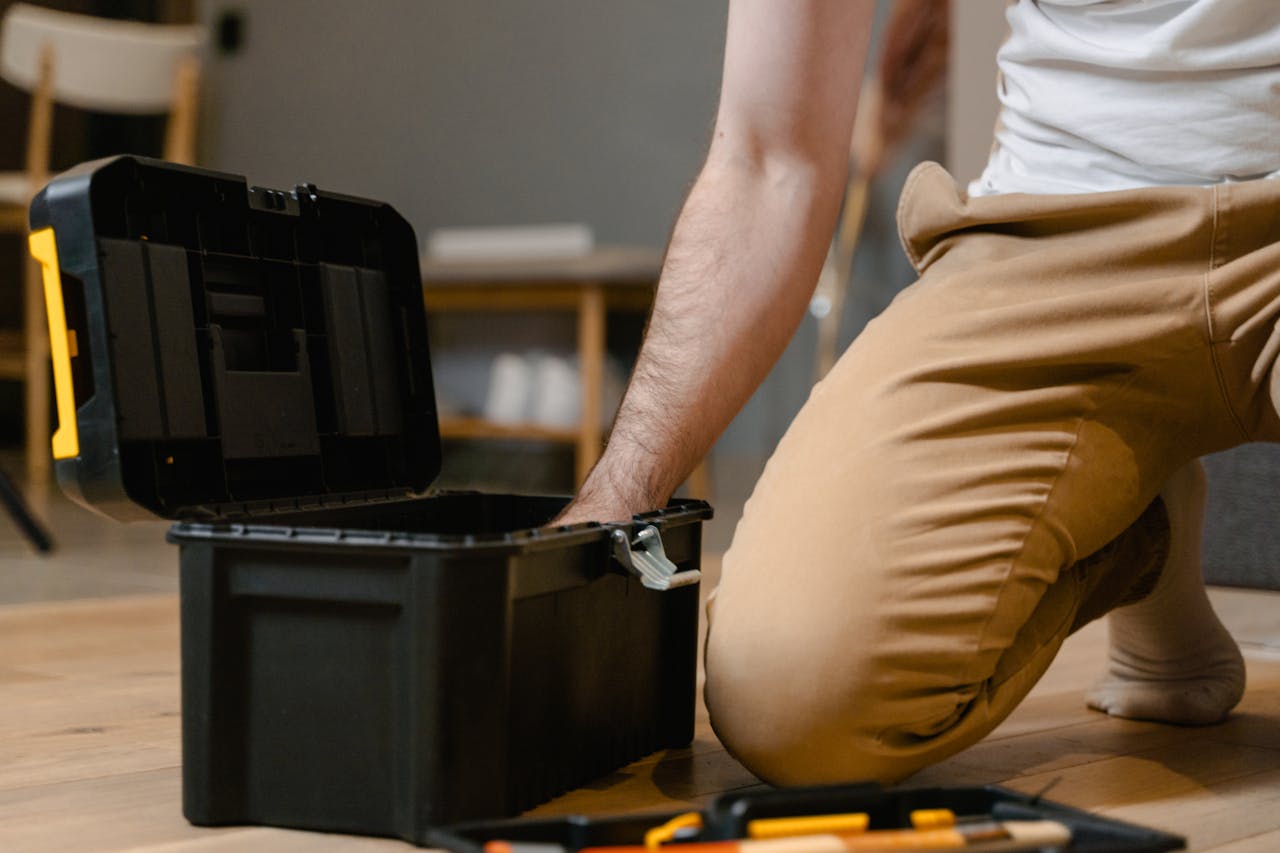 Home A man opening a tool box indoors, preparing for home repair.